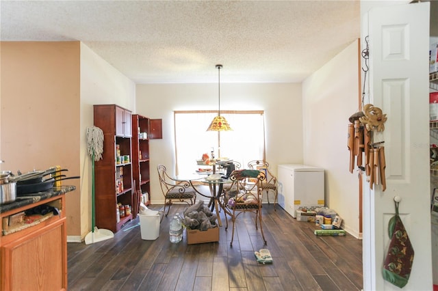2305 Rio Grande Forest Ln, Kissimmee, FL 34759 - dining space featuring dark wood-style floors, a textured ceiling, and baseboards