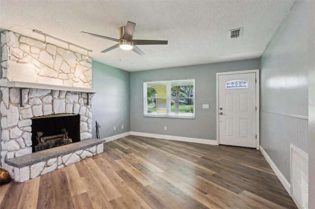 2704 Yule Tree Dr, Edgewater, FL 32141 - unfurnished living room with a textured ceiling, a ceiling fan, wood finished floors, a fireplace, and baseboards