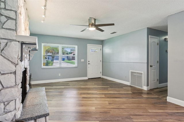 2704 Yule Tree Dr, Edgewater, FL 32141 - unfurnished living room with a ceiling fan, wood finished floors, a fireplace, and a textured ceiling