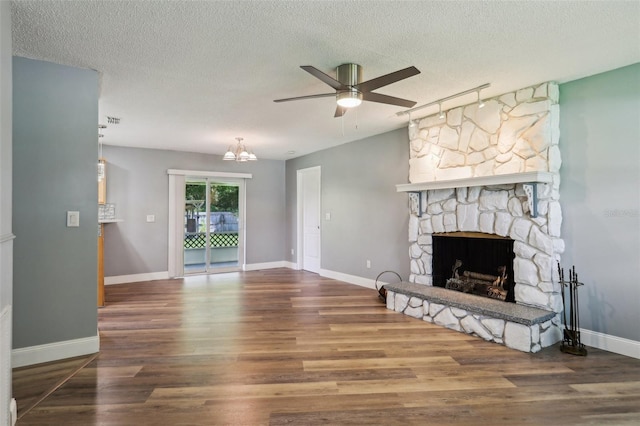 2704 Yule Tree Dr, Edgewater, FL 32141 - unfurnished living room with wood finished floors, ceiling fan, a textured ceiling, a stone fireplace, and a chandelier