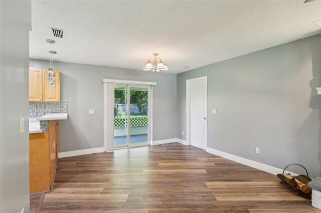 2704 Yule Tree Dr, Edgewater, FL 32141 - unfurnished dining area with a chandelier, wood finished floors, baseboards, and a textured ceiling