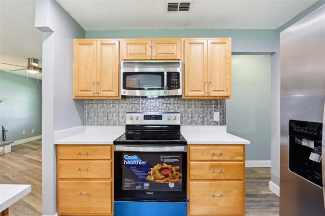 2704 Yule Tree Dr, Edgewater, FL 32141 - kitchen with appliances with stainless steel finishes, light brown cabinets, light countertops, and light wood-style flooring