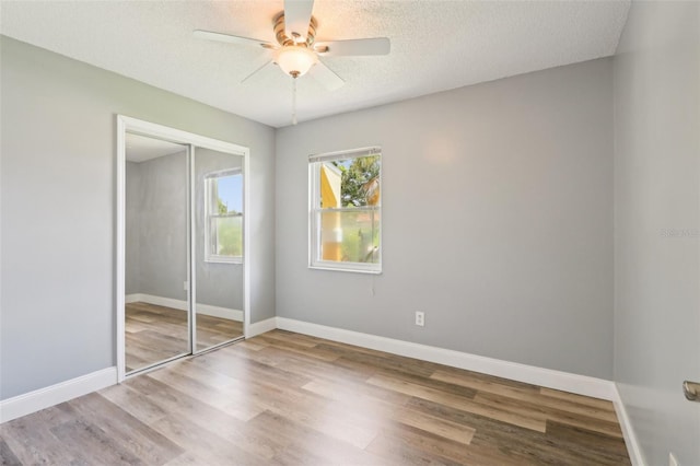 2704 Yule Tree Dr, Edgewater, FL 32141 - unfurnished bedroom with a closet, wood finished floors, a textured ceiling, baseboards, and a ceiling fan