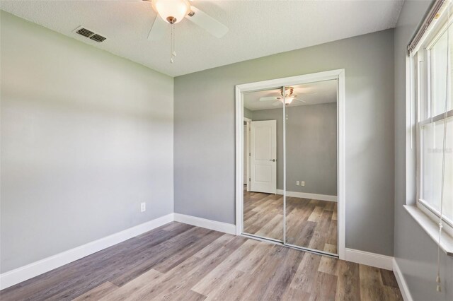 2704 Yule Tree Dr, Edgewater, FL 32141 - unfurnished bedroom featuring a closet, wood finished floors, baseboards, and multiple windows