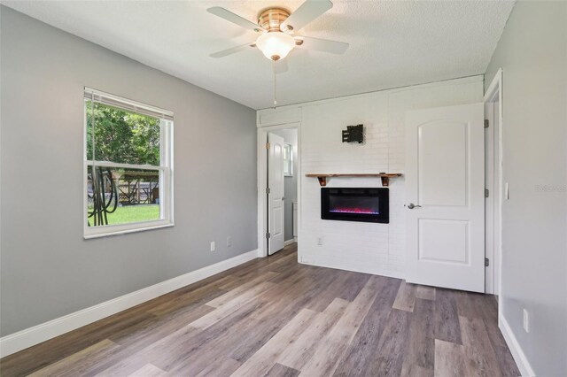 2704 Yule Tree Dr, Edgewater, FL 32141 - unfurnished living room with a glass covered fireplace, ceiling fan, wood finished floors, and baseboards