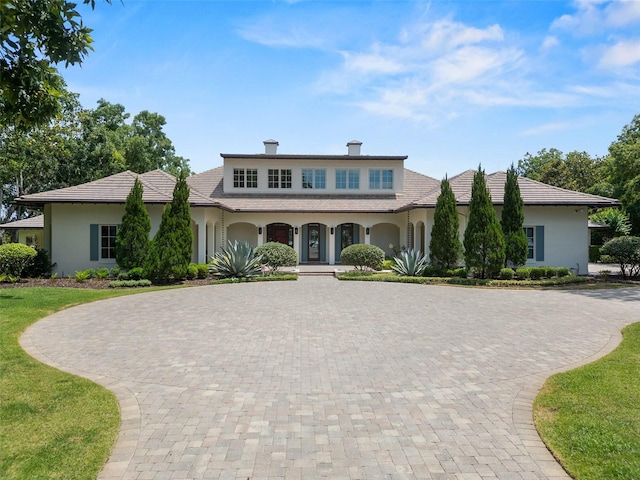 1112 Preserve Point Dr, Winter Park, FL 32789 - view of front of home featuring curved driveway, stucco siding, a porch, and a chimney