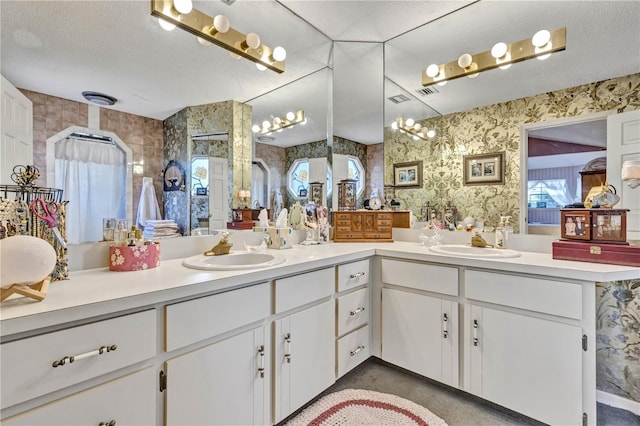 2132 Palm Vista Dr, Apopka, FL 32712 - bathroom with double vanity, wallpapered walls, and a textured ceiling