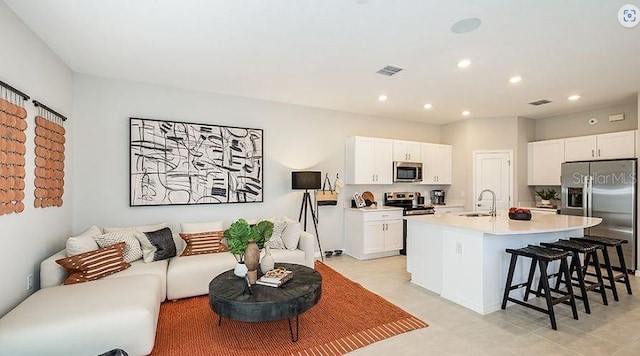 130 River Front Way, Edgewater, FL 32141 - kitchen with stainless steel appliances, a sink, a breakfast bar area, an island with sink, and light countertops