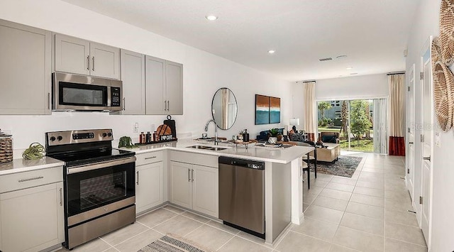 3064 Skyline Loop, Kissimmee, FL 34758 - kitchen with appliances with stainless steel finishes, a sink, a peninsula, gray cabinetry, and light countertops