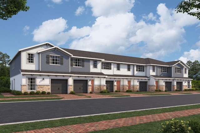 4244 Campsite Loop, Orlando, FL 32824 - townhome / multi-family property with stone siding, an attached garage, and driveway