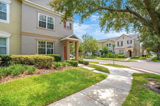 12963 Garridan Ave, Windermere, FL 34786 - view of front of house with stucco siding, a residential view, and a front lawn