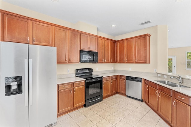 12963 Garridan Ave, Windermere, FL 34786 - kitchen with black appliances, a sink, light countertops, light tile patterned flooring, and brown cabinetry