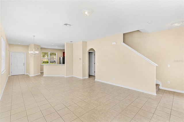 12963 Garridan Ave, Windermere, FL 34786 - unfurnished living room featuring light tile patterned floors, a chandelier, stairway, arched walkways, and baseboards