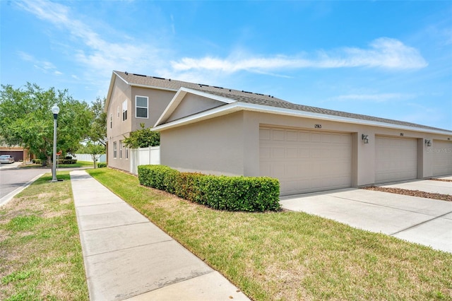12963 Garridan Ave, Windermere, FL 34786 - view of property exterior featuring stucco siding, concrete driveway, and a yard