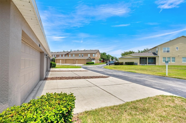 12963 Garridan Ave, Windermere, FL 34786 - view of green lawn with a garage, a residential view, and driveway
