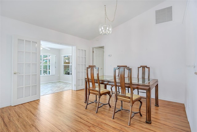 5382 SW 84th Pl, Ocala, FL 34476 - dining area featuring light wood-type flooring, a chandelier, baseboards, lofted ceiling, and french doors