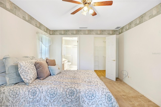 5382 SW 84th Pl, Ocala, FL 34476 - bedroom featuring a walk in closet, baseboards, ensuite bath, light colored carpet, and a ceiling fan