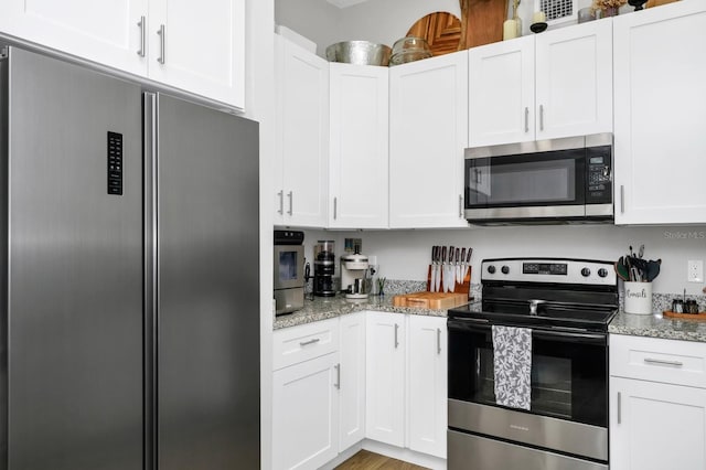 7616 Simms Ave, Orlando, FL 32812 - kitchen with appliances with stainless steel finishes, white cabinetry, and light stone counters