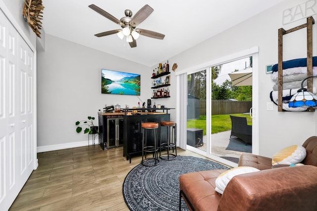 7616 Simms Ave, Orlando, FL 32812 - living area featuring wood finished floors, a ceiling fan, lofted ceiling, baseboards, and a bar