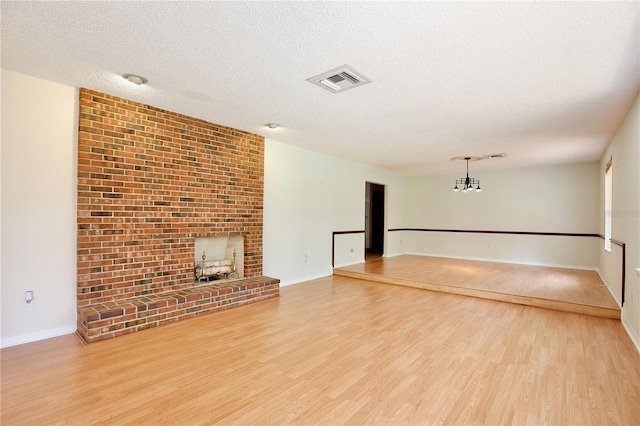4802 Anton Ave, Apopka, FL 32712 - unfurnished living room featuring wood finished floors, a textured ceiling, baseboards, and a brick fireplace