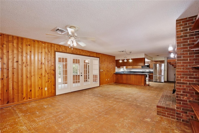 4802 Anton Ave, Apopka, FL 32712 - unfurnished living room featuring wooden walls, ceiling fan, a textured ceiling, and light flooring