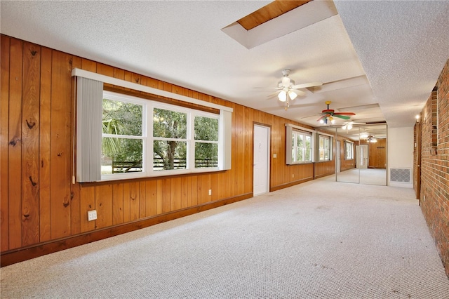 4802 Anton Ave, Apopka, FL 32712 - unfurnished living room with ceiling fan, a textured ceiling, carpet flooring, wooden walls, and baseboards