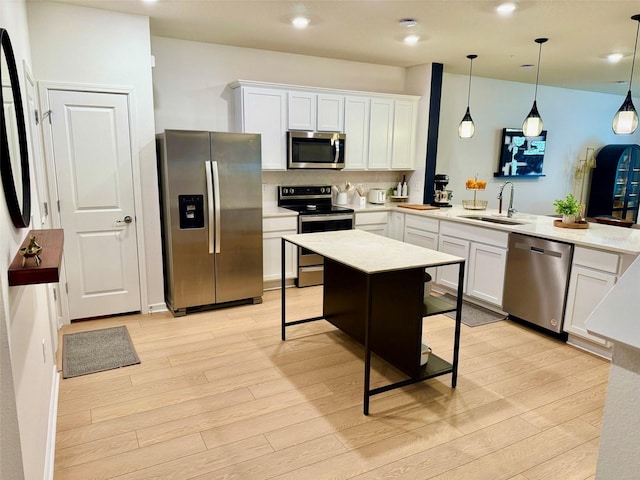 1900 Erudite Way, Winter Park, FL 32792 - kitchen featuring stainless steel appliances, a sink, light wood finished floors, a peninsula, and light countertops