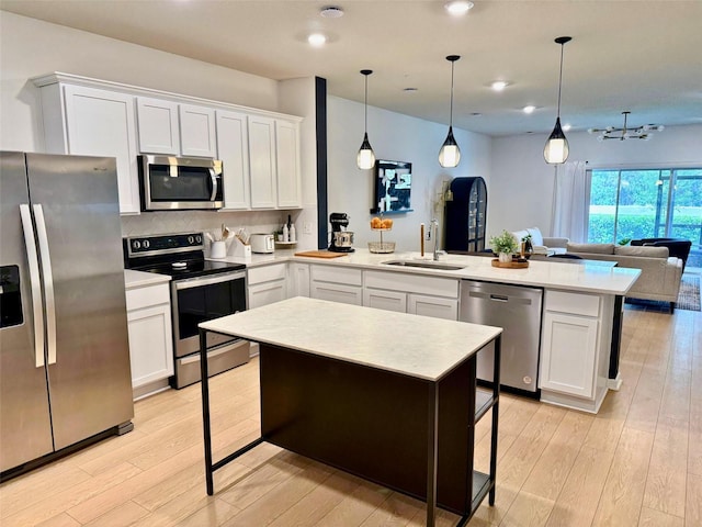 1900 Erudite Way, Winter Park, FL 32792 - kitchen featuring stainless steel appliances, a sink, a peninsula, light wood-style floors, and open floor plan