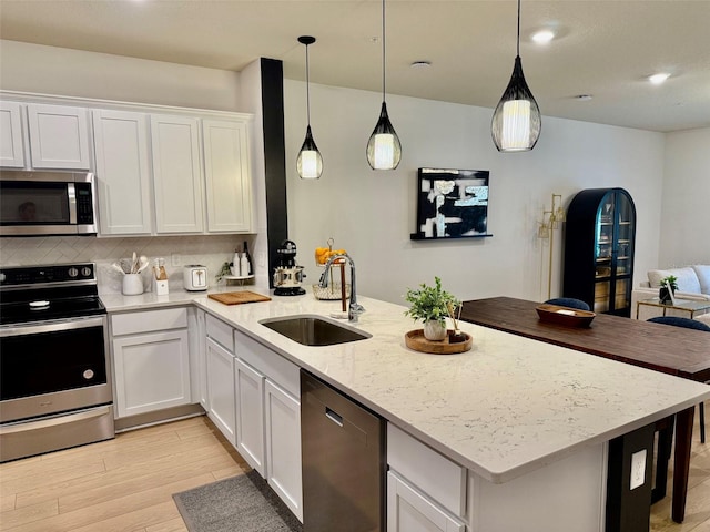 1900 Erudite Way, Winter Park, FL 32792 - kitchen with stainless steel appliances, a sink, a peninsula, open floor plan, and light wood-style flooring
