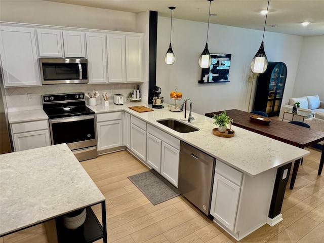 1900 Erudite Way, Winter Park, FL 32792 - kitchen featuring appliances with stainless steel finishes, a sink, a peninsula, backsplash, and light wood finished floors