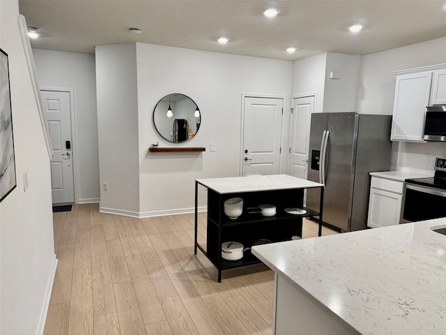 1900 Erudite Way, Winter Park, FL 32792 - kitchen featuring appliances with stainless steel finishes, white cabinetry, light wood finished floors, baseboards, and light stone countertops