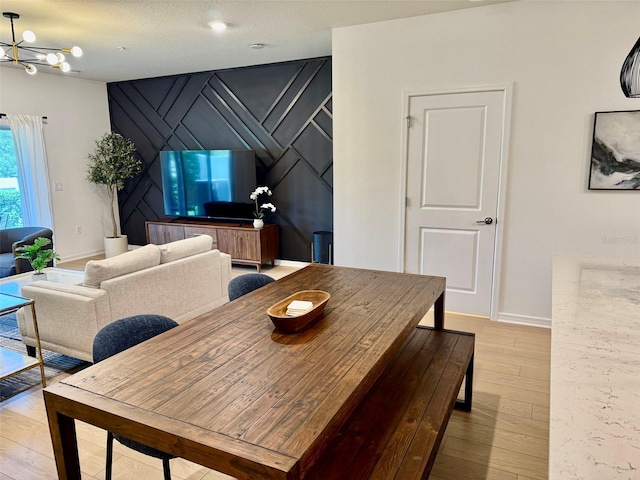 1900 Erudite Way, Winter Park, FL 32792 - dining area with a chandelier, light wood finished floors, baseboards, and an accent wall