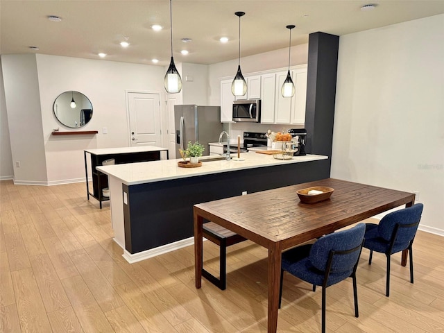 1900 Erudite Way, Winter Park, FL 32792 - kitchen with stainless steel appliances, light wood-style floors, a sink, a peninsula, and light countertops