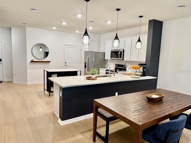 1900 Erudite Way, Winter Park, FL 32792 - kitchen featuring appliances with stainless steel finishes, light wood-style flooring, a center island, light countertops, and a peninsula