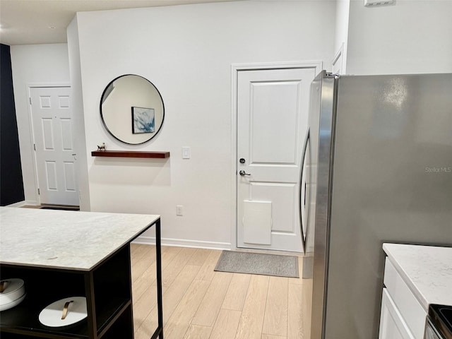 1900 Erudite Way, Winter Park, FL 32792 - kitchen with freestanding refrigerator, white cabinets, light wood-style floors, baseboards, and stove