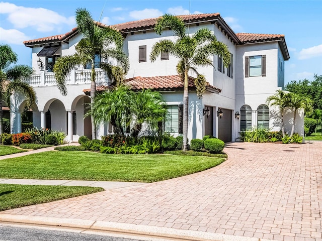 1417 Terralago Pl, Oviedo, FL 32765 - mediterranean / spanish-style home with a garage, a balcony, a tiled roof, a front lawn, and decorative driveway