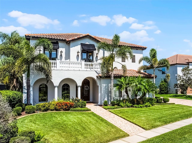 1417 Terralago Pl, Oviedo, FL 32765 - mediterranean / spanish house featuring a balcony, a tile roof, stucco siding, and a front yard