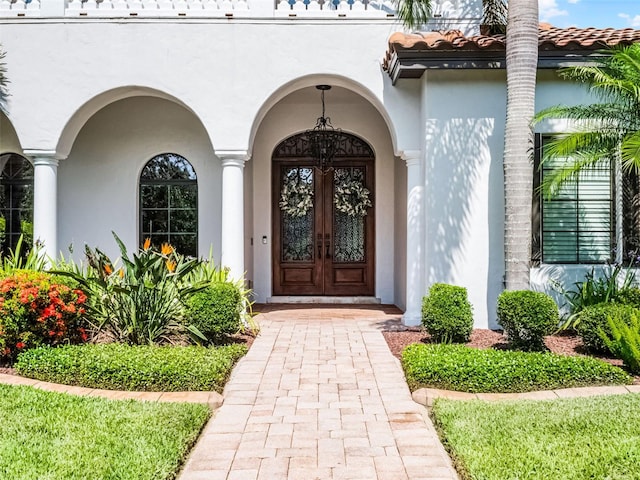 1417 Terralago Pl, Oviedo, FL 32765 - view of exterior entry featuring stucco siding, french doors, and a tile roof