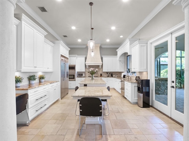 1417 Terralago Pl, Oviedo, FL 32765 - kitchen with premium range hood, stainless steel appliances, stone tile flooring, crown molding, and french doors