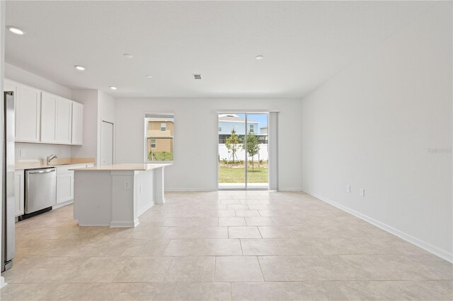 2716 Pierr St, Davenport, FL 33837 - kitchen featuring dishwasher, open floor plan, light countertops, white cabinetry, and a center island