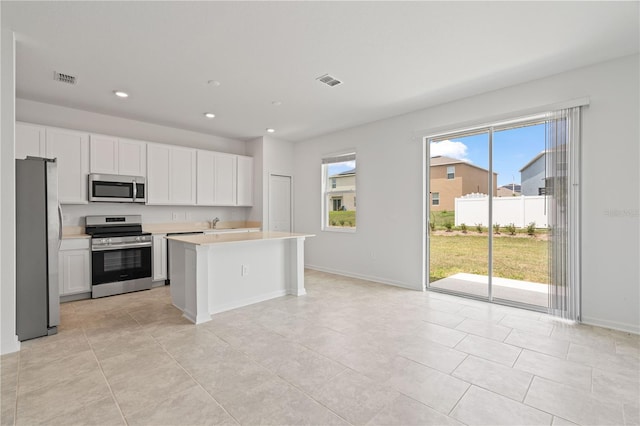 2716 Pierr St, Davenport, FL 33837 - kitchen featuring appliances with stainless steel finishes, healthy amount of natural light, light countertops, recessed lighting, and white cabinetry
