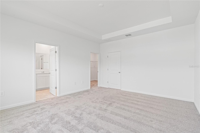 2716 Pierr St, Davenport, FL 33837 - unfurnished bedroom with light carpet, a walk in closet, baseboards, and ensuite bath