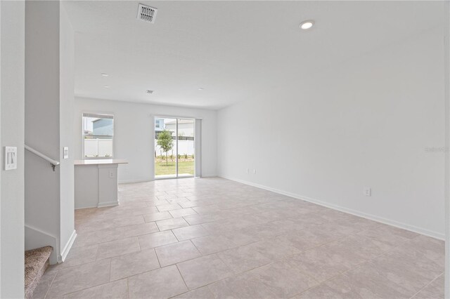 2716 Pierr St, Davenport, FL 33837 - empty room with light tile patterned floors, baseboards, stairway, and recessed lighting