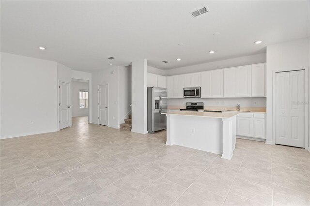 2716 Pierr St, Davenport, FL 33837 - kitchen featuring stainless steel appliances, a sink, light countertops, white cabinetry, and open floor plan