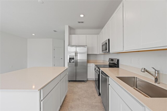 2716 Pierr St, Davenport, FL 33837 - kitchen with appliances with stainless steel finishes, a sink, white cabinetry, recessed lighting, and light countertops