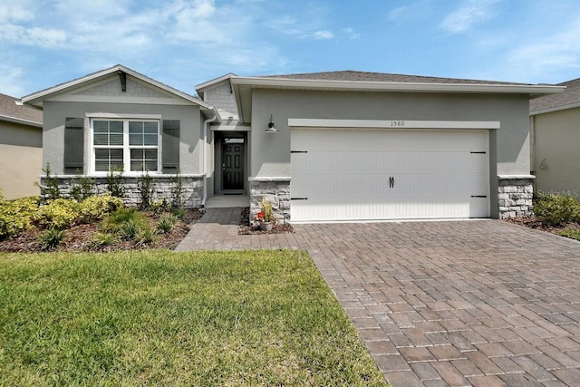 1580 Delphi Way, New Smyrna Beach, FL 32168 - ranch-style home featuring stone siding, stucco siding, driveway, a garage, and a front lawn