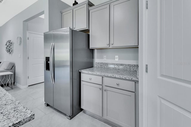 1580 Delphi Way, New Smyrna Beach, FL 32168 - kitchen with stainless steel fridge, gray cabinetry, light stone counters, and baseboards