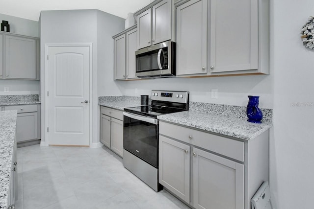 1580 Delphi Way, New Smyrna Beach, FL 32168 - kitchen featuring appliances with stainless steel finishes, gray cabinets, and light stone countertops