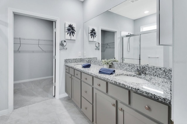 1580 Delphi Way, New Smyrna Beach, FL 32168 - full bathroom featuring double vanity, a walk in closet, a shower stall, and baseboards