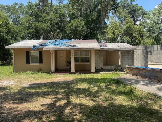 625 E Jackson Ave, Mount Dora, FL 32757 - bungalow-style home featuring a front lawn, a porch, and concrete block siding